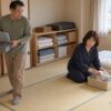 別室で眠る場所を空けるため、手芸道具を片づける52歳の奈津紀と釣り具を運ぶ55歳の夫のイメージ