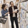 スーパーの日用品売り場で、詰め替え用洗剤の量を見比べる56歳の彰比古と54歳の紗央里のイメージ