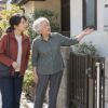 貸家の外で給湯器を見ながら、財産管理について話す53歳の娘と79歳の母のイメージ