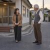 自治会の打合せの帰り道、役員の小田さんと担当範囲について話す53歳の茉由子のイメージ