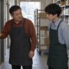 生活用品店のバックヤードで、新人に作業前の打刻を教える50歳の惇史のイメージ