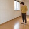 家具を運び出した賃貸の部屋で、床の傷を見つめる56歳の女性のイメージ